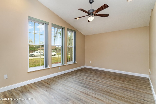 spare room with vaulted ceiling, light hardwood / wood-style flooring, plenty of natural light, and ceiling fan