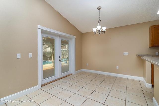 unfurnished dining area featuring light tile patterned floors, an inviting chandelier, and vaulted ceiling