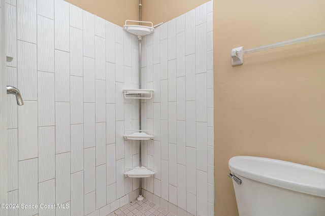 bathroom featuring tiled shower, tile patterned floors, and toilet