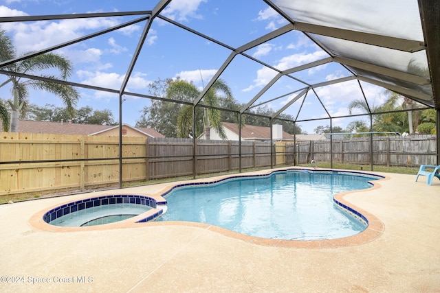 view of swimming pool featuring a lanai, an in ground hot tub, and a patio