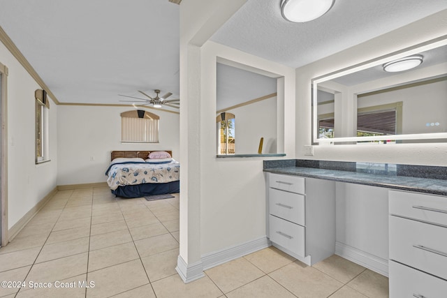 bathroom featuring a textured ceiling, vanity, ceiling fan, crown molding, and tile patterned flooring