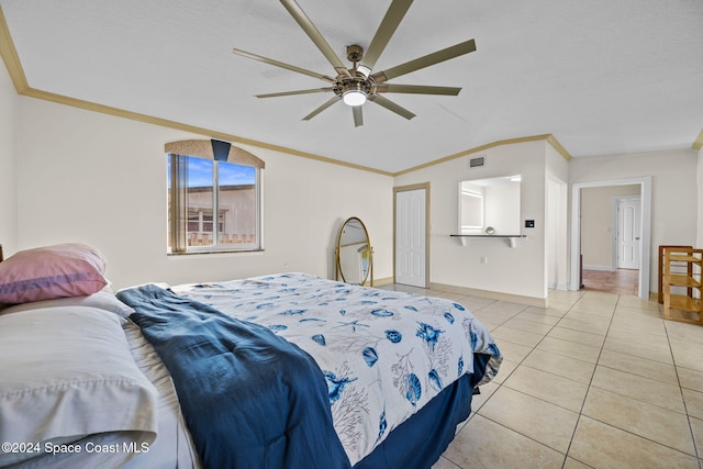 bedroom with ceiling fan, crown molding, light tile patterned floors, and vaulted ceiling