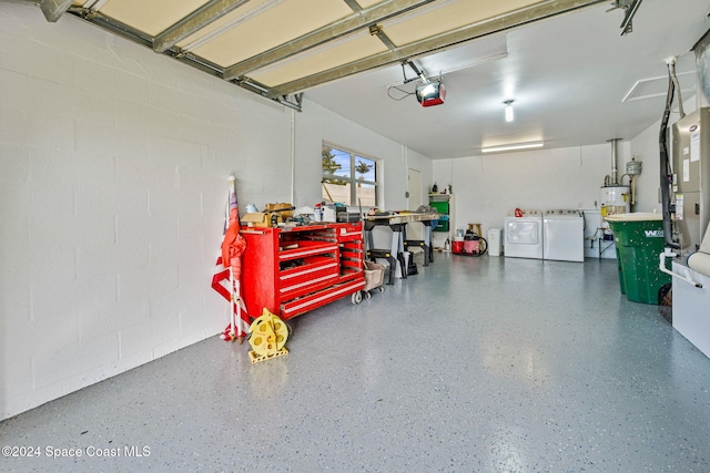 garage with gas water heater, a garage door opener, washer and clothes dryer, and water heater