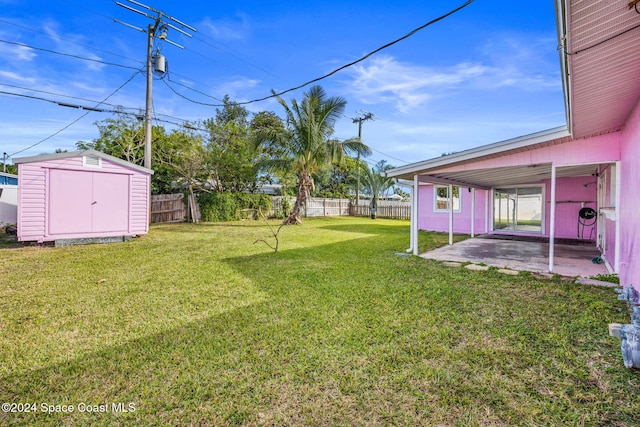 view of yard with a storage shed and a patio area