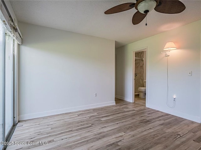 2800 Indian River Blvd Unit L-2, Vero Beach, FL 32960 - unfurnished bedroom featuring light wood finished floors, ensuite bath, baseboards, a ceiling fan, and a textured ceiling