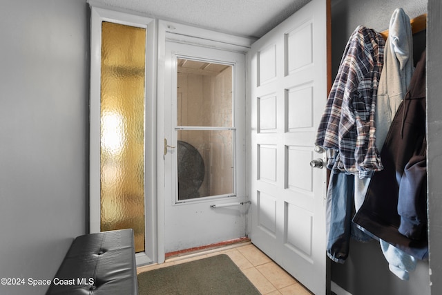 bathroom with a textured ceiling and tile patterned floors