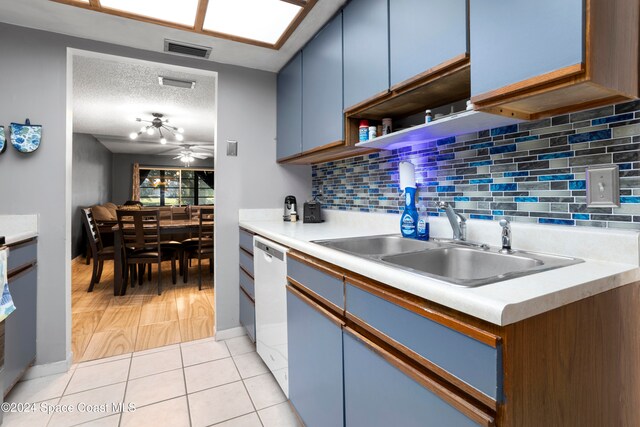 kitchen with ceiling fan, tasteful backsplash, white dishwasher, a textured ceiling, and light tile patterned flooring