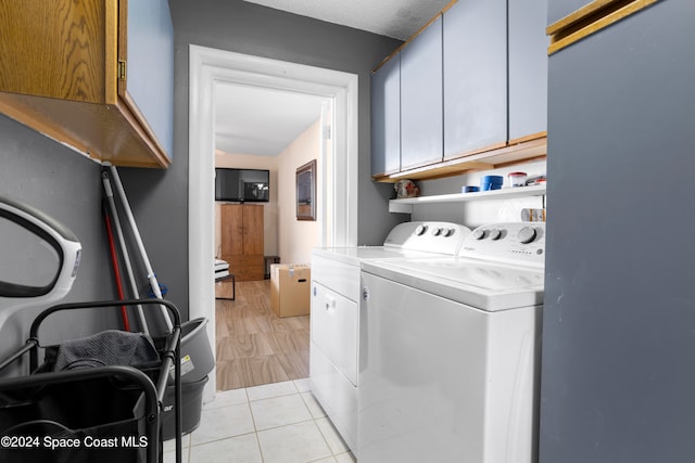 laundry room with light hardwood / wood-style flooring, cabinets, and independent washer and dryer