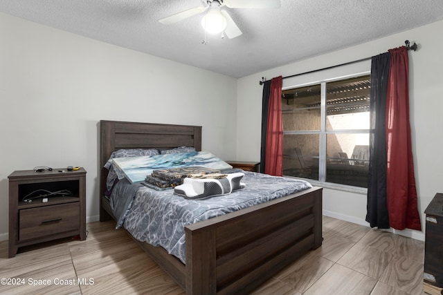 bedroom featuring ceiling fan and a textured ceiling