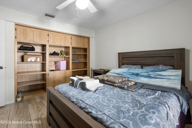 bedroom featuring ceiling fan and a textured ceiling