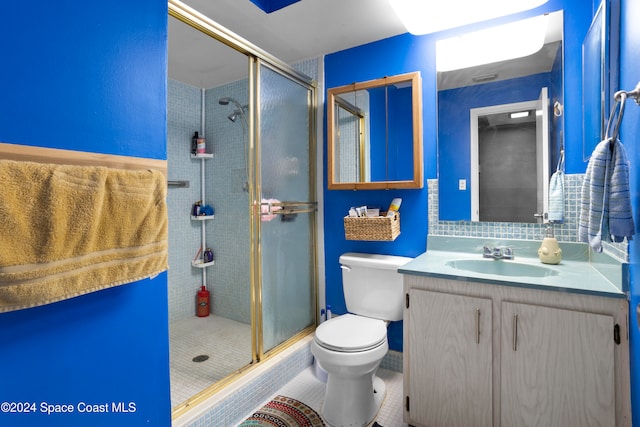 bathroom featuring walk in shower, tile patterned flooring, vanity, and toilet