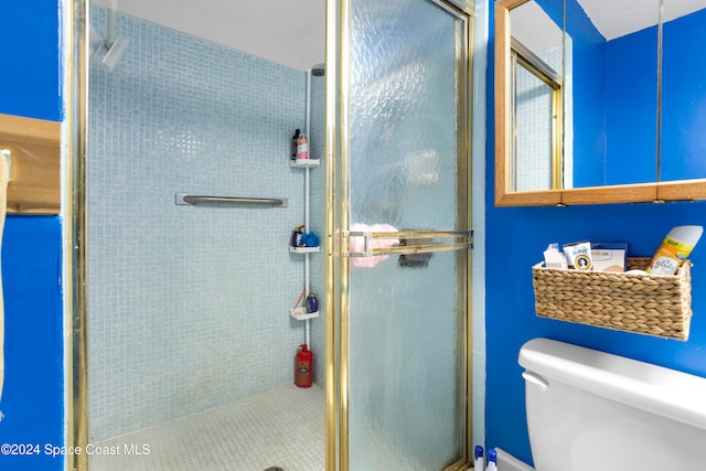 bathroom with toilet and an enclosed shower