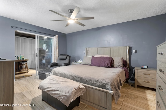 bedroom with ceiling fan and a textured ceiling