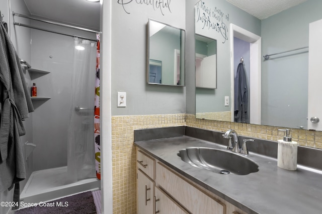 bathroom featuring a shower with shower curtain, vanity, and decorative backsplash