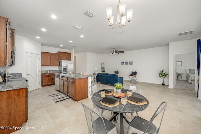 dining space with light tile patterned floors, ceiling fan with notable chandelier, and a textured ceiling