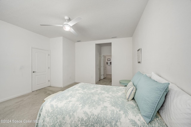 carpeted bedroom featuring a textured ceiling and ceiling fan