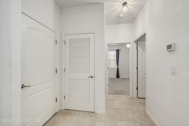 hall featuring light tile patterned floors