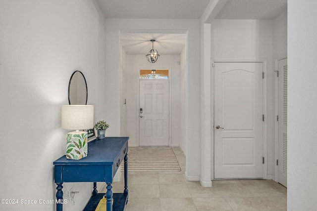 entrance foyer featuring a notable chandelier and light tile patterned flooring