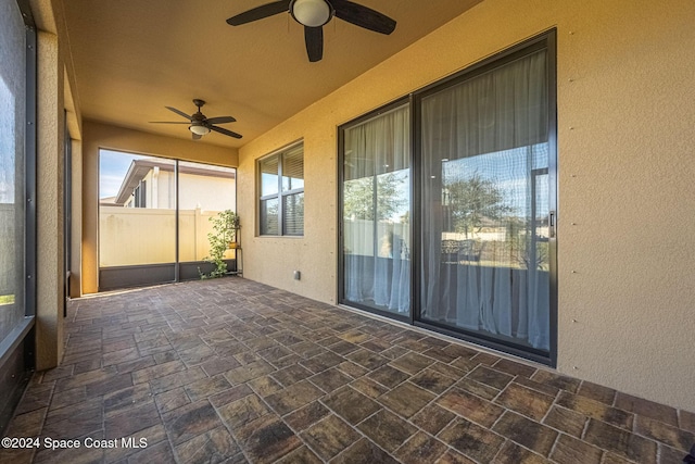 unfurnished sunroom with ceiling fan