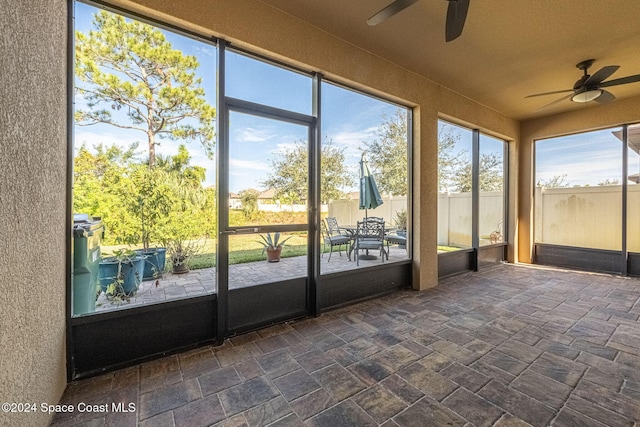 unfurnished sunroom with ceiling fan