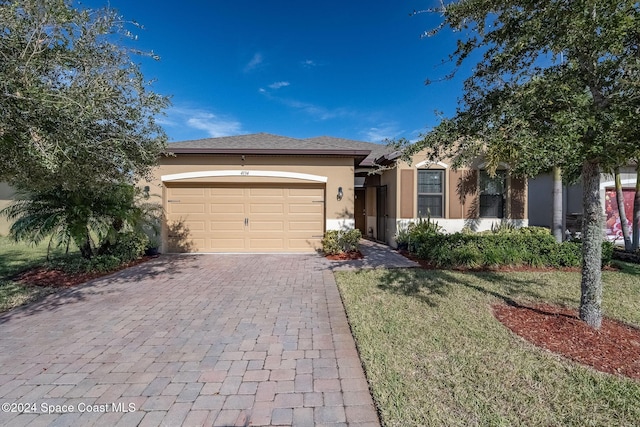 ranch-style home featuring a garage and a front lawn