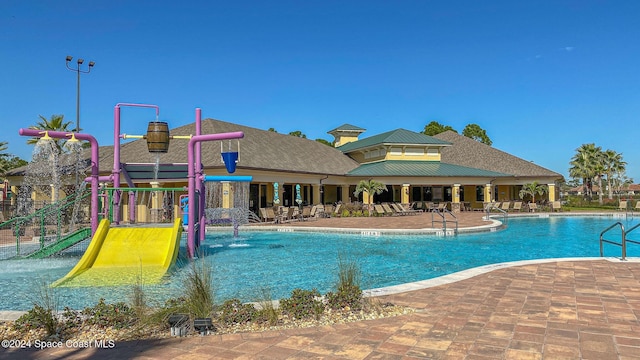 view of pool with a playground and pool water feature