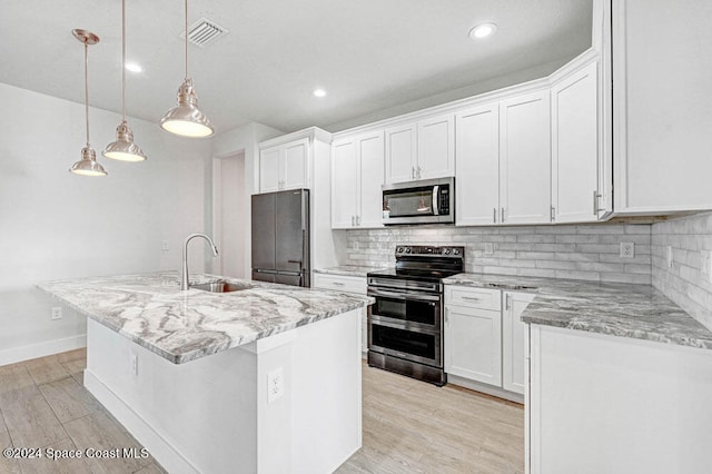 kitchen featuring sink, pendant lighting, a kitchen island with sink, white cabinets, and appliances with stainless steel finishes