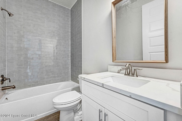 full bathroom featuring tiled shower / bath combo, toilet, wood-type flooring, and vanity