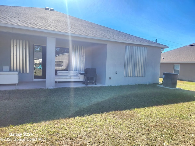 1631 Wake Forest Rd NW, Palm Bay, FL 32907 - rear view of house with a shingled roof, stucco siding, and a lawn