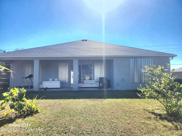 1631 Wake Forest Rd NW, Palm Bay, FL 32907 - back of property featuring a porch, a shingled roof, stucco siding, and a lawn