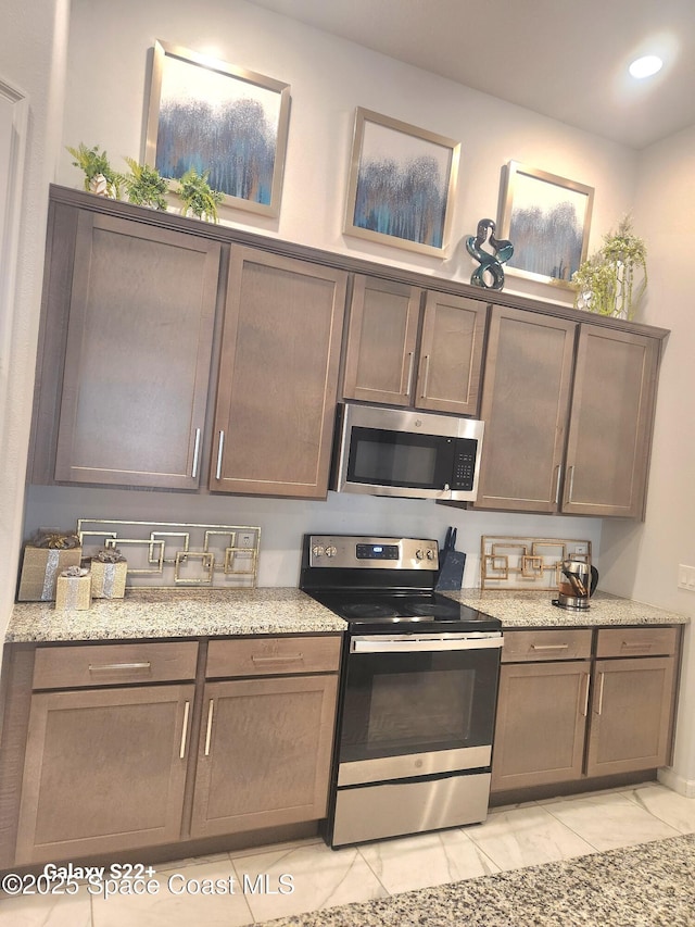 1631 Wake Forest Rd NW, Palm Bay, FL 32907 - kitchen with light stone counters, recessed lighting, and stainless steel appliances