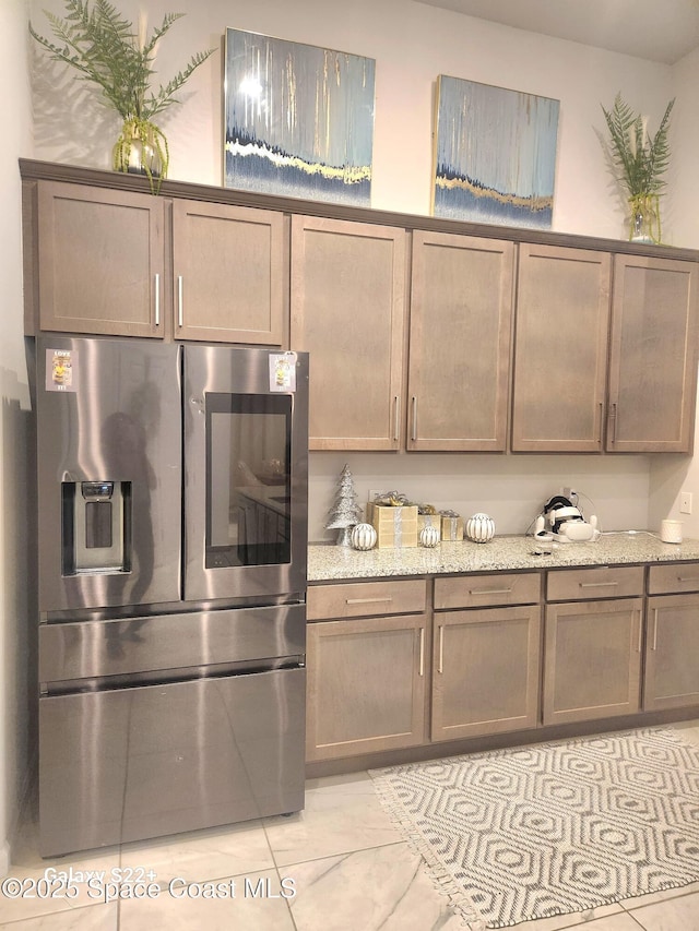 1631 Wake Forest Rd NW, Palm Bay, FL 32907 - kitchen with light stone counters and stainless steel refrigerator with ice dispenser