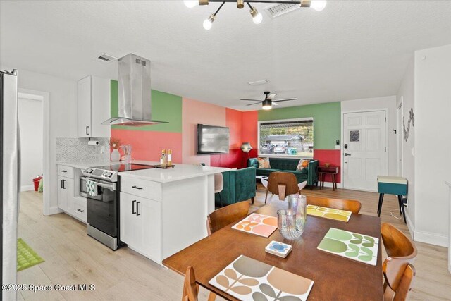 kitchen with electric range, tasteful backsplash, light hardwood / wood-style flooring, ventilation hood, and white cabinets