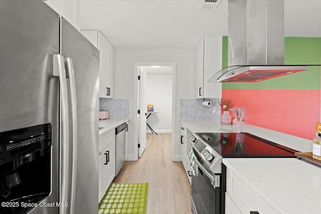 kitchen featuring ventilation hood, white cabinets, appliances with stainless steel finishes, and tasteful backsplash