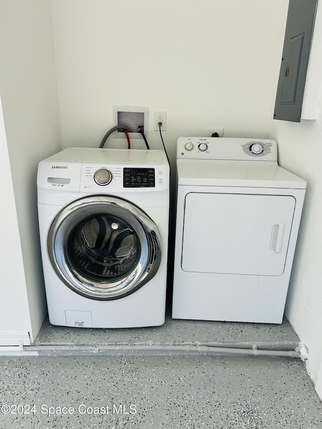 washroom featuring electric panel and washer and clothes dryer