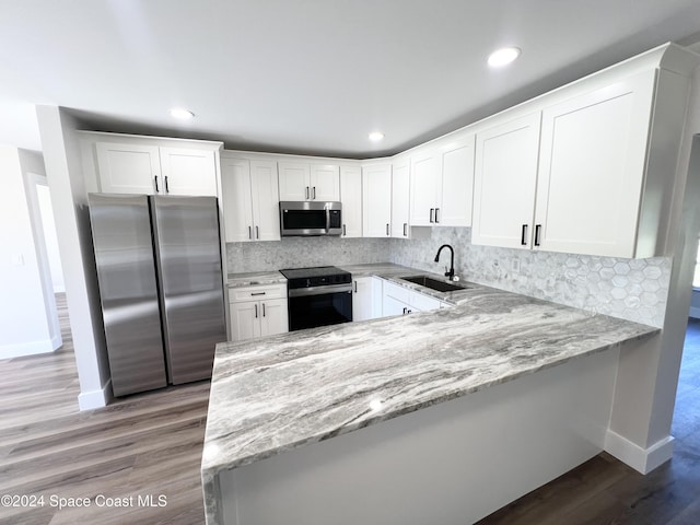 kitchen featuring stainless steel appliances, white cabinetry, tasteful backsplash, and sink