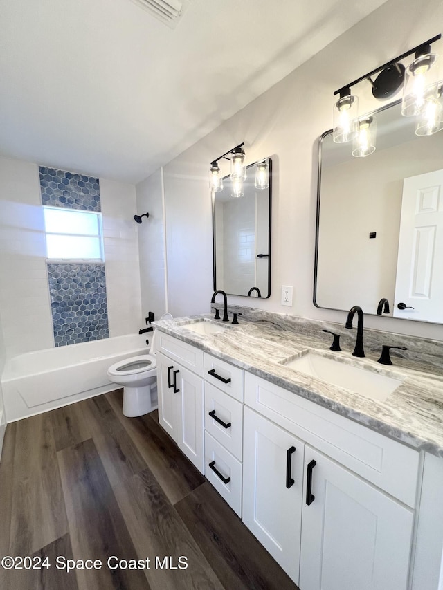 full bathroom featuring vanity, toilet, wood-type flooring, and tiled shower / bath