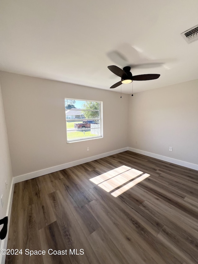 unfurnished room featuring ceiling fan and dark wood-type flooring