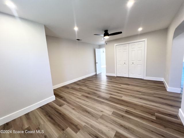 unfurnished bedroom featuring ceiling fan, wood-type flooring, and a closet