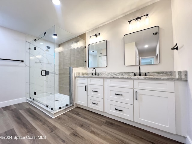 bathroom with wood-type flooring, vanity, and an enclosed shower