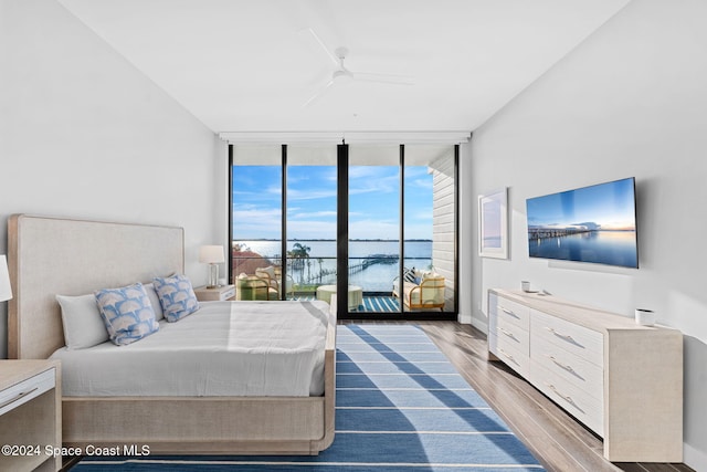 bedroom featuring floor to ceiling windows, access to exterior, ceiling fan, and wood-type flooring