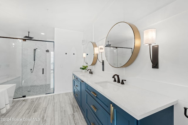 bathroom featuring vanity, wood-type flooring, and a shower with door