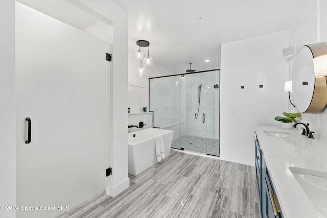 bathroom with hardwood / wood-style flooring, vanity, and plus walk in shower