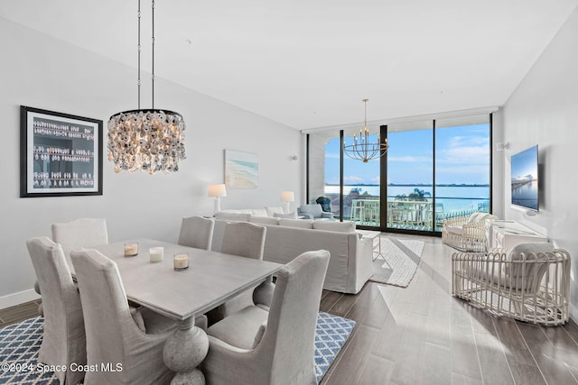 dining space featuring hardwood / wood-style flooring, a wall of windows, and a notable chandelier