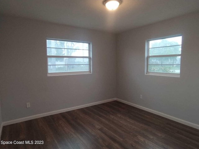 unfurnished room with a wealth of natural light and dark wood-type flooring