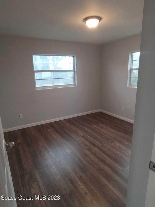 unfurnished room featuring dark wood-type flooring