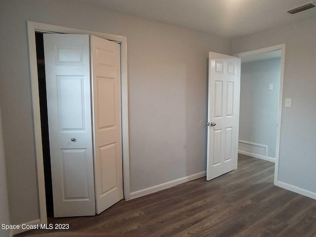 unfurnished bedroom featuring dark hardwood / wood-style floors and a closet