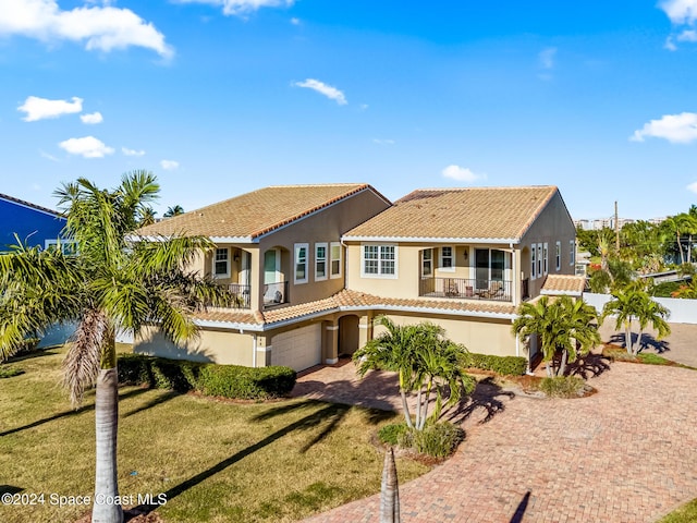 mediterranean / spanish house with a garage and a front lawn