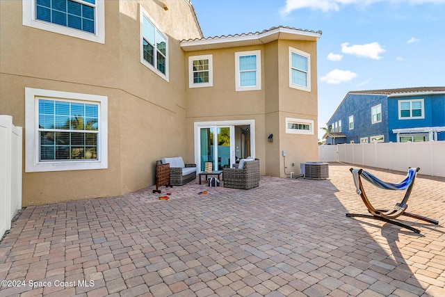 back of house featuring central AC, a patio, and an outdoor hangout area