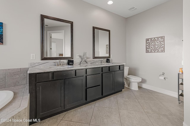 bathroom featuring tile patterned floors, tiled bath, vanity, and toilet